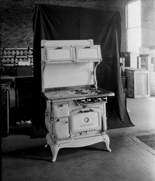 A monogram stove in an appliance warehouse set up in front of a dark backdrop.