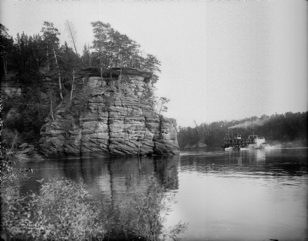 Steamboat near a cliff on the Wisconsin River, presumably in the Wisconsin Dells.