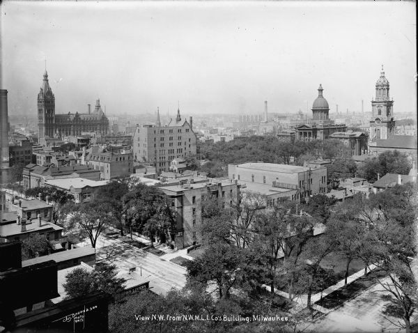 Looking northwest from the roof of Northwestern Mutual home office at E. Wisconsin Avenue and N. Van Buren Street toward City Hall, Milwaukee courthouse and St. John's Cathedral. Caption on glass plate reads: " View N.W. from N.W.M.L.I. Co's Building".