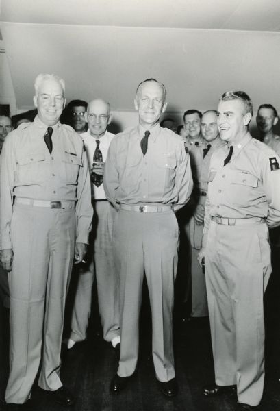 General Ralph Zwicker (center), commandant of Camp Kilmer and a native of Stoughton, Wisconsin.  In 1954, General Zwicker became a central figure in Senator Joseph R. McCarthy's contest with the Army.  Summoned to testify before McCarthy's committee (McCarthy was the only member present), on February 18, ostensibly to answer questions about an Army dentist alleged to have subversive connections, Zwicker was subjected to a humiliating cross examination.  McCarthy charged that Zwicker was protecting Communists and that he was unfit to wear a uniform.  This brought both Secretary of the Army Stevens and President Eisenhower to Zwicker's defense and set the stage for the Army-McCarthy Hearings.  They inturn led to McCarthy's downfall.  This undated photograph of Zwicker was taken at an Army Reserve unit party at Camp Kilmer.