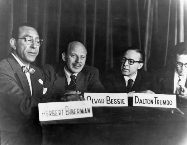 Four members of the Hollywood Ten at an unidentified event concerning their defense.  From left to right are: Herbert Biberman, Alvah Bessie, and Dalton Trumbo. Ring Lardner, Jr. is the individual on the right.