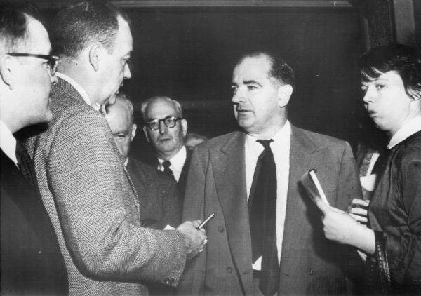 After closed door hearings at the Boston Federal Building, Senator Joseph R. McCarthy talks to the press about subversive activities at the General Electric Company. Such closed door sessions left McCarthy free to shape the reporting of a day's disclosures.