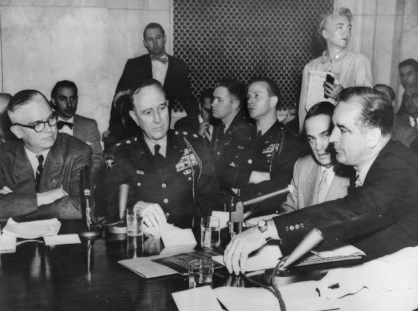 Secretary of the Army Robert Stevens (left) watches as Senator Joseph R. McCarthy raises a point of order as the Army-McCarthy hearings begin.  Also seated at the table are General Robert Young and committee counsel Roy Cohn.  McCarthy raised points of order so frequently that filmmaker Emile de Antonio was inspired to title his documentary about the Wisconsin senator "Point of Order."