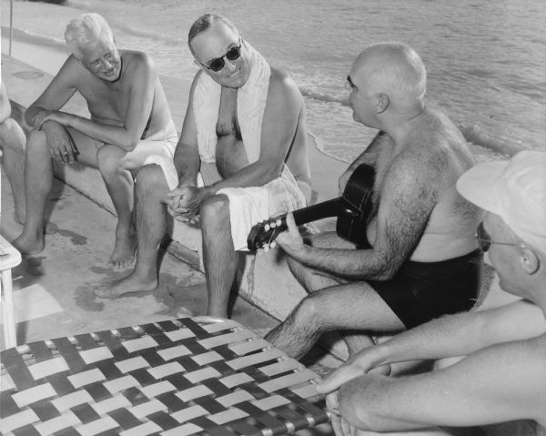 Philleo Nash (playing the guitar), Presidential adviser on Minority Affairs, entertains President Harry Truman (in the sunglasses), with folk songs during a vacation at the Little White House in Key West.  Only a few weeks later (January, 1952), Senator Joseph R. McCarthy charged that Nash, a native of Wisconsin, had Communist associations during the 1940s. The President strongly supported his assistant and Nash was totally cleared by the Loyalty Review Board. In 1956 Wisconsin elected Nash as lieutenant governor.