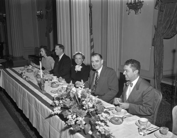 Senator Joseph R. McCarthy (second from the right), seated at the head table at a banquet meeting of the Dane County Young Republicans' Club. Other people are, left to right: Miriam Wigderson, William Stern, chairman of the second district YGOP; Marian Fox, chairman of the Dane Co. Women's Republican club; Sen. Joseph McCarthy, and Attorney Maurice Wigderson, chairman of the Dane Co. YGOP organization. McCarthy attacked 78 Madisonians as "dupes and dopes of the Communist Party" because of an anti-McCarthy petition they had signed. Curiously, on the following day, Owen Lattimore, who was one of the primary targets of McCarthy's espionage attacks, was also in Madison to speak.