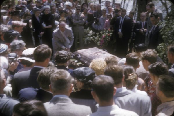 Mourners surround the casket of Senator Joseph R. McCarthy at his funeral at St. Mary's Roman Catholic Cemetery.