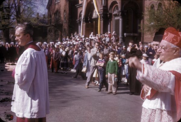 The crowd gathered outside St. Mary's Catholic Church for the funeral of Senator Joseph R. McCarthy watches as the procession to the cemetery begins.