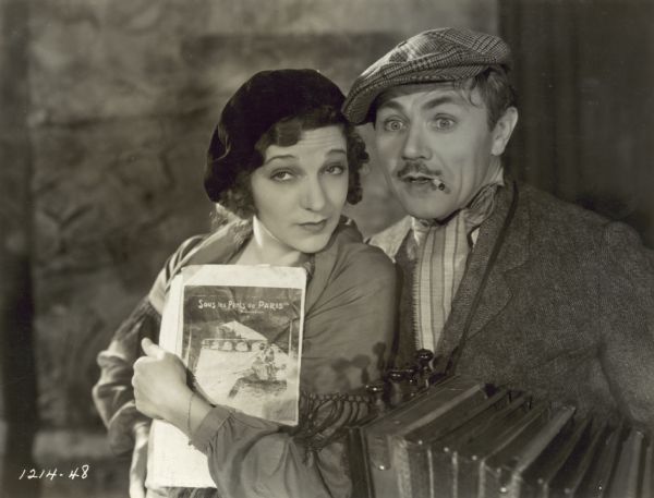 Georgie (played by Gertrude Lawrence), clutching sheet music, leans in close to Zisi who holds an accordion (Charles Ruggles) in a scene from the Paramount musical "The Battle of Paris."