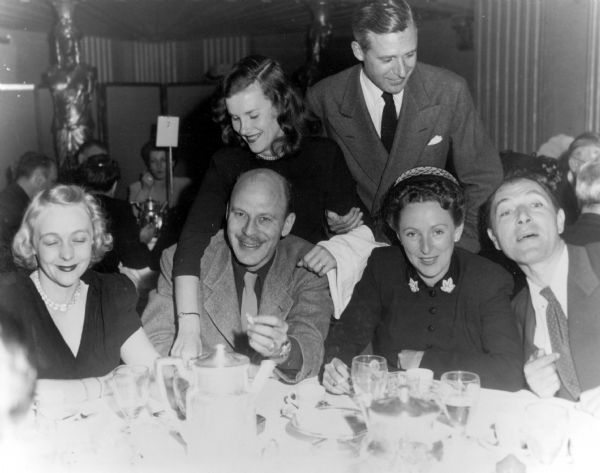 One of the Hollywood Ten, Alvah Bessie (second from left, holding a cigarette) and others at a luncheon.