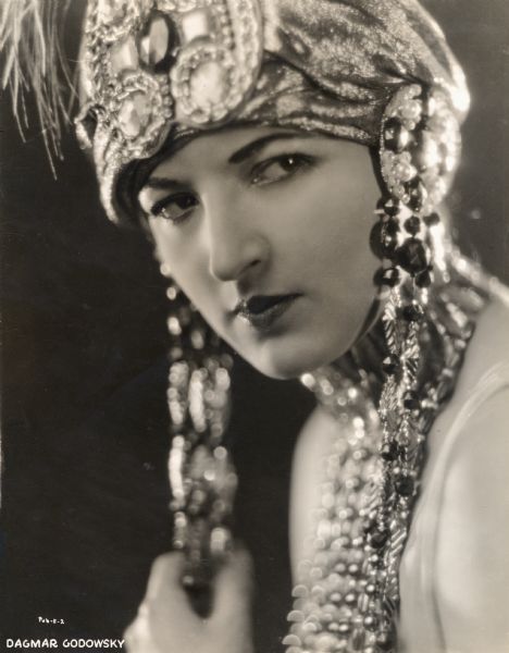 Likely a 1923 Goldwyn production <i>Red Lights</i> publicity portrait of Dagmar Godowsky wearing a beaded headdress.