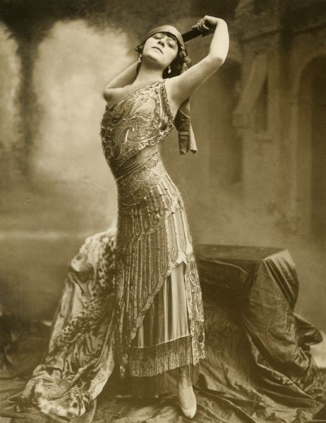 Publicity still of Valeska Suratt for the 1911 Broadway production <i>The Red Rose</i> in which Suratt played Lola, a Parisian artist's model who falls in love with an American student.

Original caption:
"Valeska Suratt in <i>The Red Rose,</i> a new musical comedy by Harry B. and Robert B. Smith, music by Robert Hood Bowers, directon of Lee Harrison. Garrick Theater, May 1."
