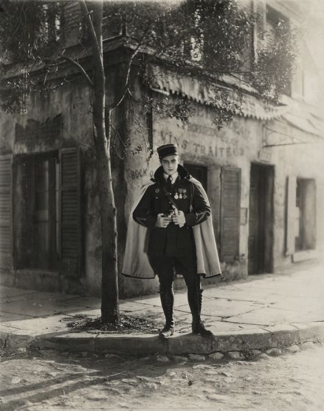 Ramon Novarro on a motion picture set dressed as a French army officer, perhaps from <i>Mr. Barnes of New York</i>.