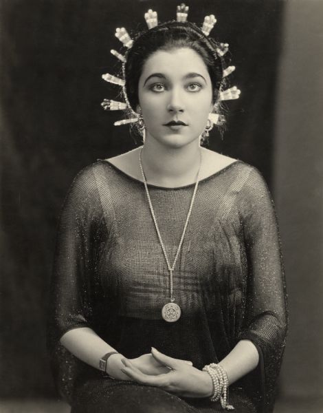 Seated three-quarter length portrait of Nita Naldi by Donald Biddle Keyes, 1922. Naldi has 12 silver Spanish combs in her hair that are brightly backlit.

Original caption:
"Nita Naldi as 'Dona Sol' in the Paramount Picture <i>Blood and Sand.</i>"