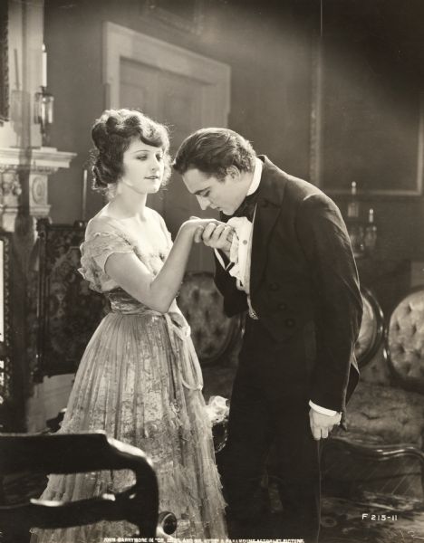 John Barrymore, as Dr. Henry Jekyll, kisses the hand of Martha Mansfield, as Millicent Carew, in a production still from <i>Dr. Jekyll and Mr. Hyde</i> (Famous Players-Lasky 1920).