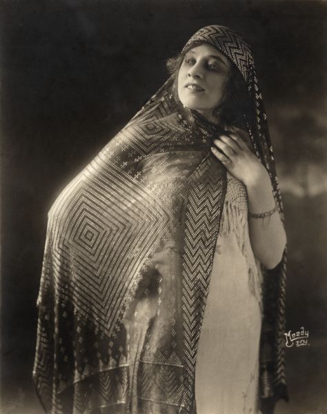 Three-quarter length portrait of Lenore Ulric as Paula Figueroa in the 1916 Pallas film <i>The Heart of Paula.</i> (She dropped the H from Ulrich sometime after 1917.)

Original caption:
"Lenore Ulrich, the Morosco-Paramount film star as she appears in <i>The Heart of Paula,</i> a Pallas Pictures release. Miss Ulrich was loaned to Pallas Pictures by Oliver Morosco for this one subject."