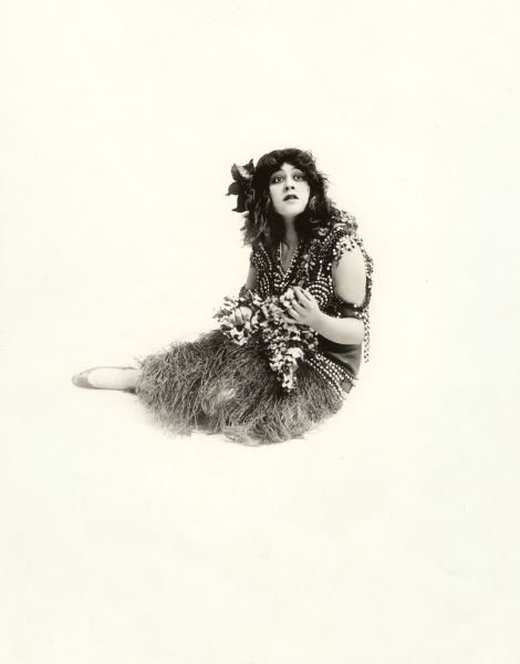 In this publicity still for the 1915 Triumph film release <i>The Better Woman,</i> Lenore Ulric wears a grass skirt and a quantity of beads.