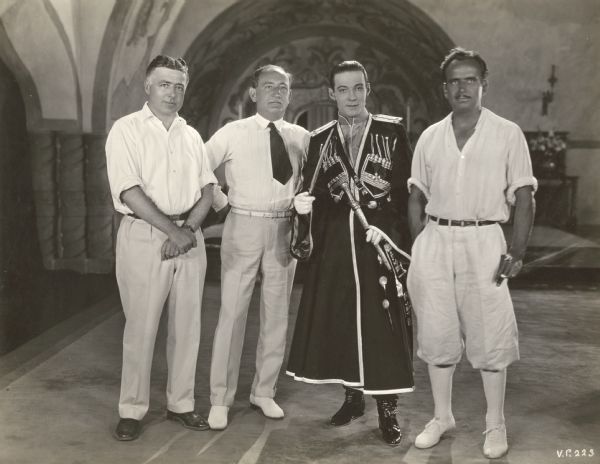 From left to right, Clarence Brown (director), Joseph M. Schenck, Rudolph Valentino (dressed for the role of Vladimir Dubrovsky), and Douglas Fairbanks, in a publicity still on the set of the 1925 production <i>The Eagle.</i>
