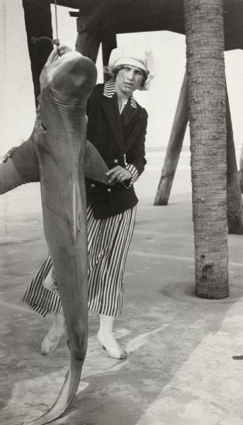 Valda Valkyrien wears a very smart vertically striped dress under a dark double-breasted jacket. Apparently she has just caught a shark on a Florida beach. The Thanhouser Film Corporation, for which she worked from 1915 to 1917, filmed in Jacksonville, Florida, during the winters.