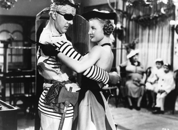 Scene still of Jacques Tati as Mr. Hulot dressed as a pirate dancing with Nathalie Pascaud (Martine) in <i>Les Vacances de M. Hulot (Mr. Hulot's Holiday,</i> 1953).