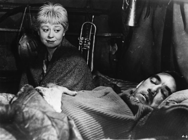 Giulietta Masina, as Gelsomina, watches the sleeping Anthony Quinn, as Zampanò, in Federico Fellini's <i>La Strada</i> (1954).