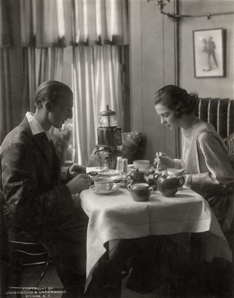 The celebrated dancing partners Vernon Castle and Irene Castle eating breakfast at home.