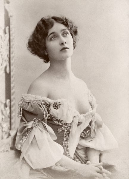 The young Italian operatic soprano Lina Cavalieri in suggestive deshabille, her pearl decorated dress falling off her shoulders.