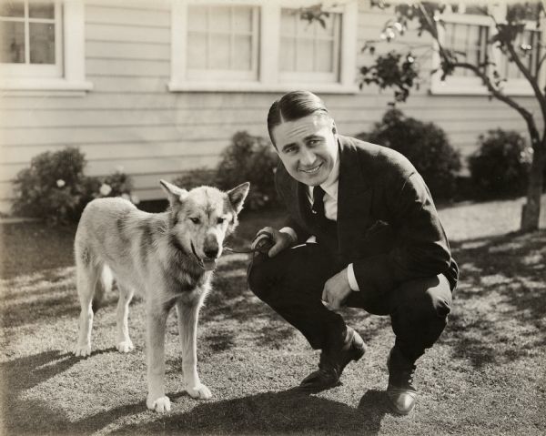 Sydney Chaplin (Charlie Chaplin's brother) and a German shepherd dog.<p>Original title:
"Syd Chaplin and 'Prince,' a war hero, cited three times for bravery on the fields of Flanders, captured from the Prussian Guards by Captain Aubrey Chaplin, Syd's cousin, and brought to Los Angeles by an American soldier. The dumb hero succumbed recently after being run down by an automobile outside the Chaplin estate."