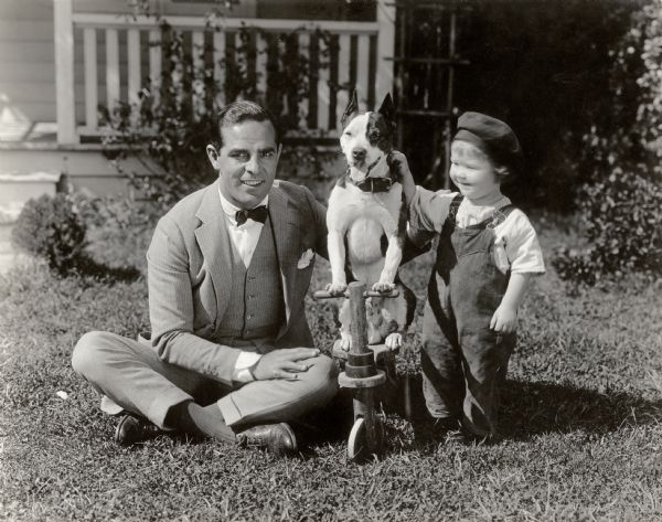 Original caption:
"This boy's parents never could see moving picture actors until Antonio Moreno rented the bungalow next to theirs in Hollywood. Now they swear by him--for does he not let Junior play with his dog? Film stars aren't such a bad lot afterall."