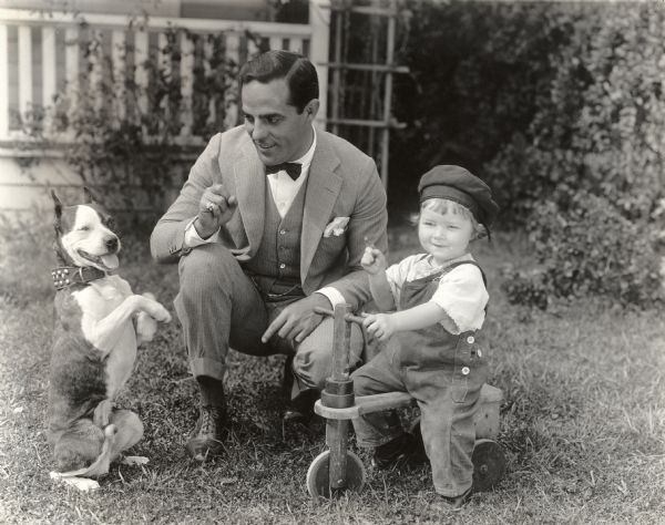 Original caption:
"Antonio Moreno with his dog, Don Juan, sitting up on his haunches, and a friend. The three are rehearsing Tony's new serial, just commenced at the Vitagraph western studio."