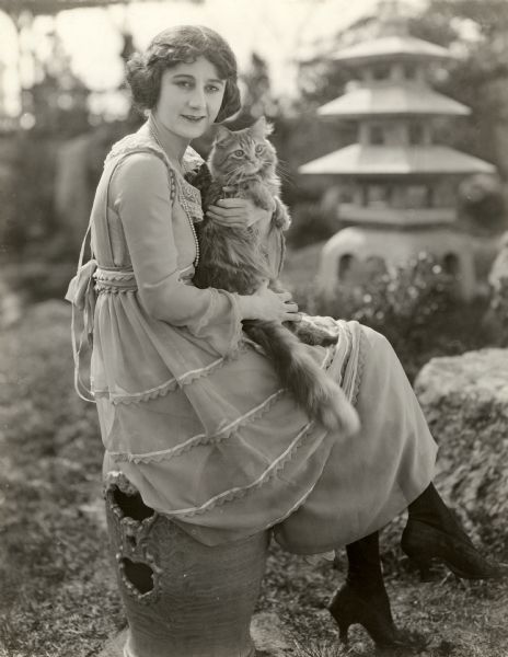 Original caption:
"Ruth Stonehouse, one of the featured players in the all star cast of <i>The Hope,</i> the latest in Metro's series of pictures founded on the Drury Lane melodramas, with her prize winning cat. Every time Leo enters a cat show he comes home with a new blue ribbon and Miss Stonehouse loves him none the less on that account--Blue Ribbon being scarce these days."