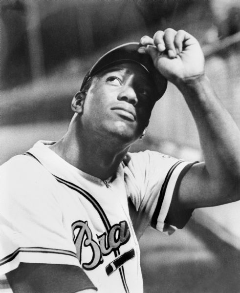 Portrait of Milwaukee Braves outfielder Wes Covington holding the brim of his cap.