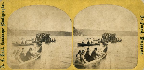 Stereograph of a very large number of judges standing crowded at the very small end of a pier in Devil's Lake. The occasion is the Grand Regatta held June 21-22, 1877.