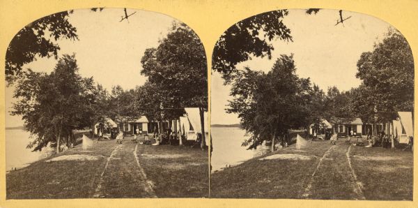 Several men and women sit outdoors on the grounds of Bain's Camp in Twin Lakes, Wisconsin.