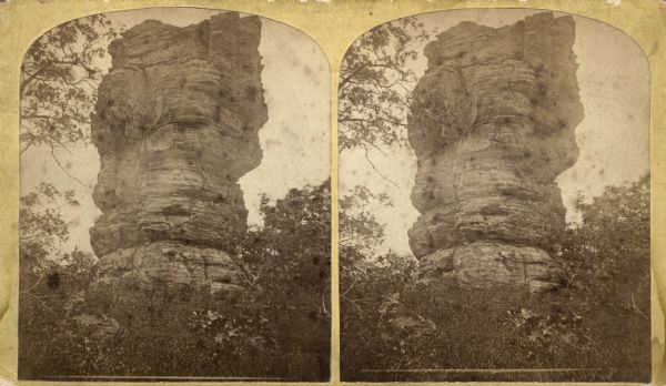View of the rock formation named Devil's Chimney. A quotation on the back of the stereograph reads, "A rock 50 feet high, 25 feet diameter at the base and 50 feet at the top."