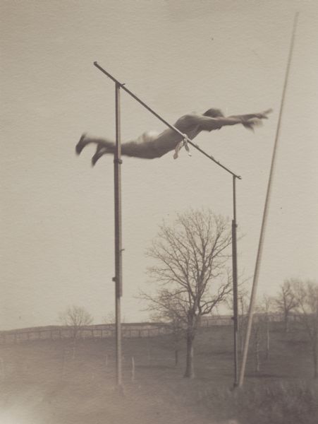Carl Moore Wheelock, member of the Menomonie High School class of 1905, depicted as a professional athlete, competing in a pole vault competition. Part of a yearbook created by classmate Albert Hansen, based on a class prophecy theme.