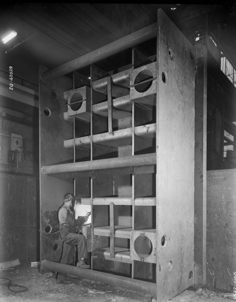 A worker welds together sections of a press slide that was later purchased by Federal Engineering and used by the automotive industry.