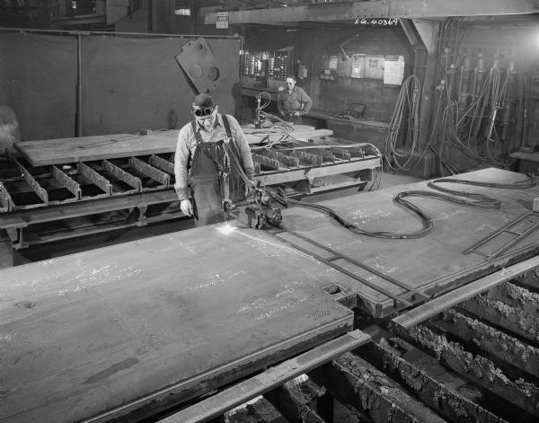 Two long-time Falk employees, Bob Quitzow and Frank Ruscitti, work in the gas cutting department. Original Falk caption reads: "View of 'Bug' cutting Department."