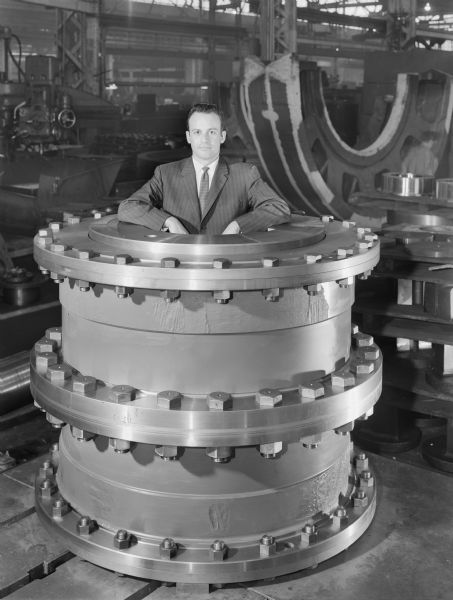 The 220 G20 gear coupling pictured was later purchased by L.W. Nash Company. Falk caption reads, "220 G20 Gear Coupling per assembly, Drawing number 418288." Male employee in photograph is C. Brickett.