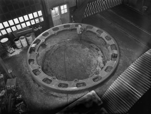 Single helical gear purchased by The Fuller Company and later used in Jamaica (as a rotary kiln). Falk caption reads, "Single helical gear, 260 teeth 99667 DP - 16 face." Male employee in photograph is Tony Pietraszewski.