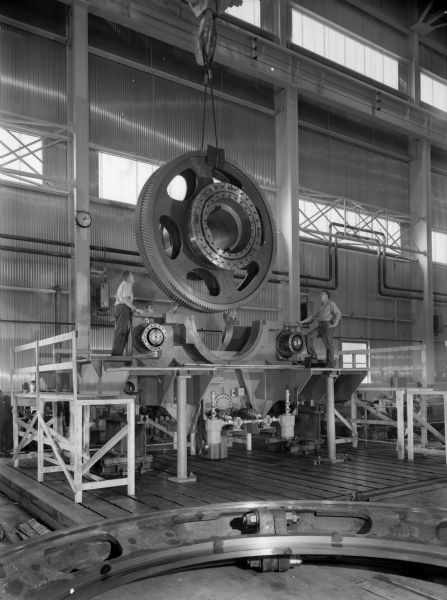 A 4 pinion BOF drive that was purchased by Pennsylvania Engineering and used by Youngstown Sheet and Tube. Original Falk caption reads, "4 pinion BOF, shaft mounted design, with 2145Y2 primary drives. See Engineering Files for exact details." Men in photograph are Ed Growan, Rob Miller, Frank Bauer and Roman Sadowski."
