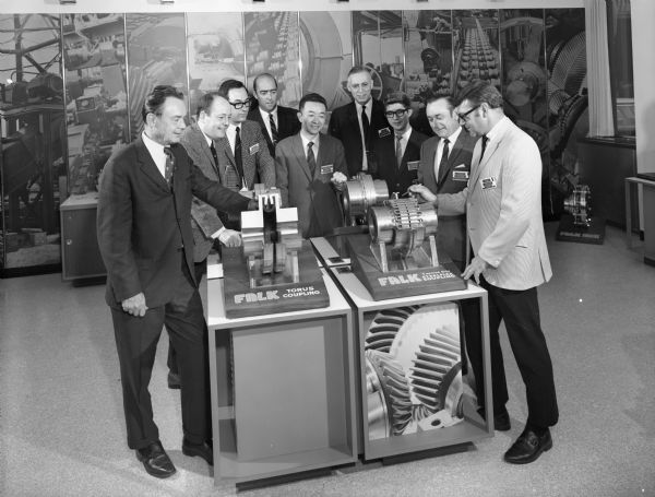 Falk caption reads, "Photo taken for publicity release and forum. Men in photo from left to right are D.K. Lambert-Director of International Sales at Falk, M. DeGruyl, A.W. Van Der Pluijm, Noel Milligan, Yoshitaka Gotoh, Alfred Weymouth, Yoshisuke Koezuka, Frank Miller, and D.J. Ovshak-Manager of Distributor Sales at Falk."