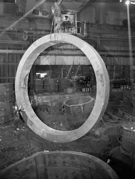 This product was purchased by Allis-Chalmers of West Allis, Wisconsin. Falk caption reads, "Solid riding ring 102,000 pound rough weight, 244 inches in diameter. Tire or riding ring for large cement kiln." Male employees in photograph are F. Chovanec and A. Cocroft.
