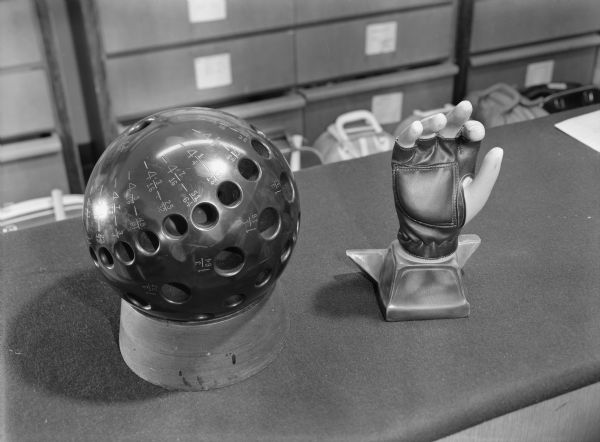 Original Falk caption reads, "Shows older 'Swiss cheese' measuring ball and Don Carter glove. Taken with permission of AMF at Personalized Bowling Company of Milwaukee for use in Sport Facts number 84."