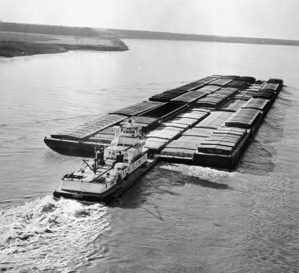 Elevated view of an inland river barge that was purchased by Electro-Motive and used by Wisconsin Barge Lines. Original Falk caption reads, "4.074:1 twin screw, 2150 BHP each. Photo shot from Electro-Motive transparency received from Electro-Motive. For use in bulletin 430. For color photo see 44TF-651." Name on boat says, "Kathryn Eckstein Milwaukee Wis".