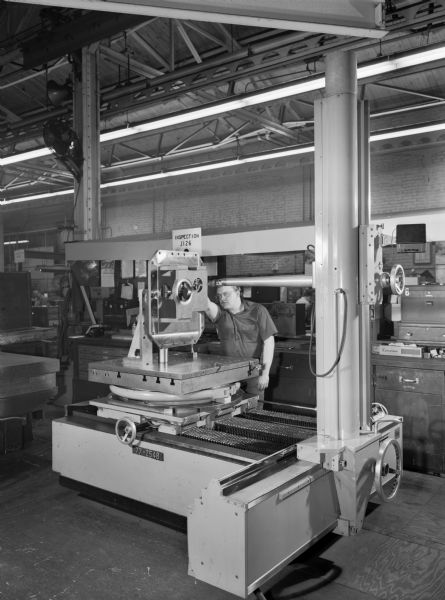 Original Falk caption reads, "Type 'F' unit housings. View of portage inspection machine in Shop 1." Male employee in photograph is Donald L. Vogt.