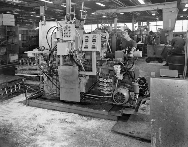 20 inch coupling slotter at Plant 2. Original Falk caption reads, "Machine number 19-7503 at Plant 2: These pictures of a 20 inch slotter taken for Jack Blank as an illustration of equipment being furnished to Falk in Mexico-for Mexican customs and import clearance." Male employee in photograph is Rolando Medrono.