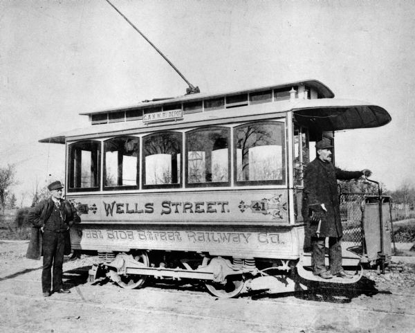 Streetcar and two operators. The side of the car reads, "Wells Street" and West Side Street Railway Co." Original Falk caption reads, "Photos borrowed from Milwaukee County Transport for use in brochure 850801. Originals returned to County. Milwaukee streetcars."