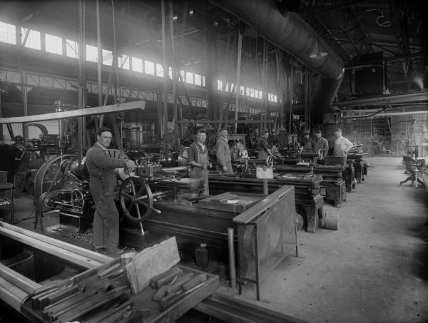 Several Falk employees at work in the machine shop where nearly each man attends to a piece of machinery. Original Falk caption reads, "Centennial historical photos of old negative which could be lost forever. Probable dates prior to World War One."