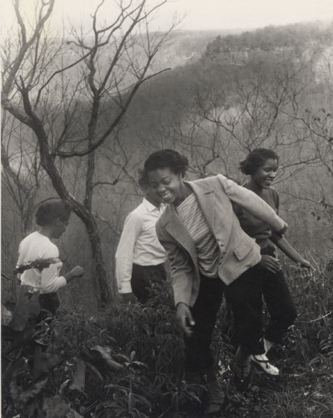Four girls hiking up a mountain as an excursion during the Clinton Youth session at Highlander Folk School. Clinton Youth was a Unitarian work camp from the early 1950s. The main building was in the office of Highlander. These camps were responsible for building the library, the film center, the community center, and for clearing the land for the lake.
