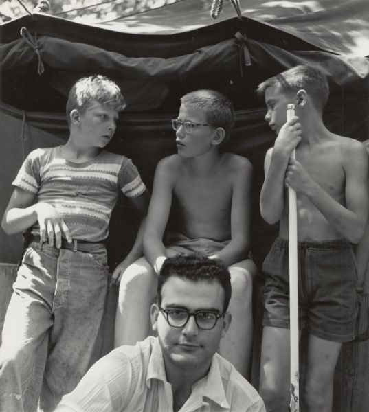 Three young boys and a man in front of a tent.  Part of Highlander Folk School's Koinonia Children's Camp. David Tate on left.